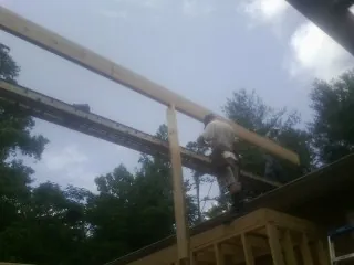 Carpenter setting a ridge beam over a new addition frame — Ice Dam Removal by Roofing Brothers in Frankton