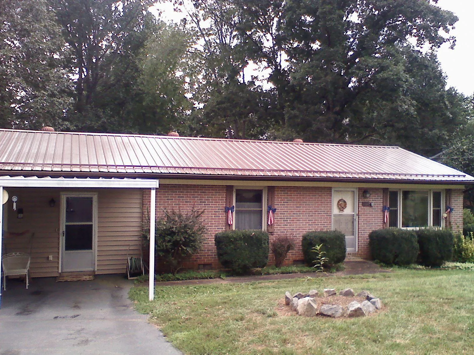 Bronze metal roof and carport on a brick ranch home — Roof Repair work by our crew in Frankton